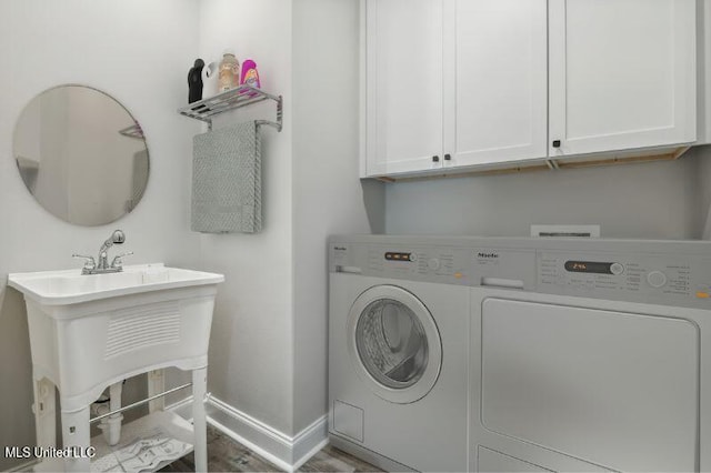 620 Old Savannah Dr, Long Beach, MS 39560 - washroom featuring separate washer and dryer, cabinet space, baseboards, and wood finished floors