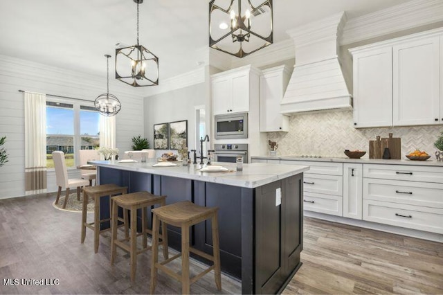 620 Old Savannah Dr, Long Beach, MS 39560 - kitchen with a chandelier, appliances with stainless steel finishes, premium range hood, white cabinetry, and crown molding