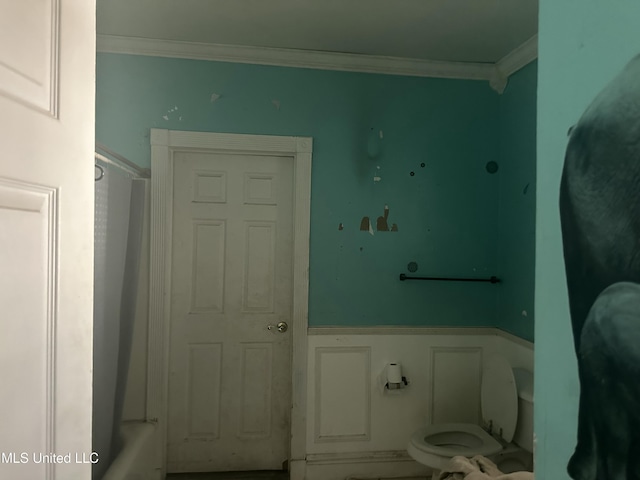 bathroom with a bath, toilet, and crown molding