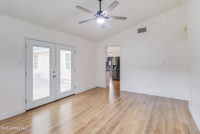 empty room with ceiling fan, lofted ceiling, french doors, and light wood finished floors