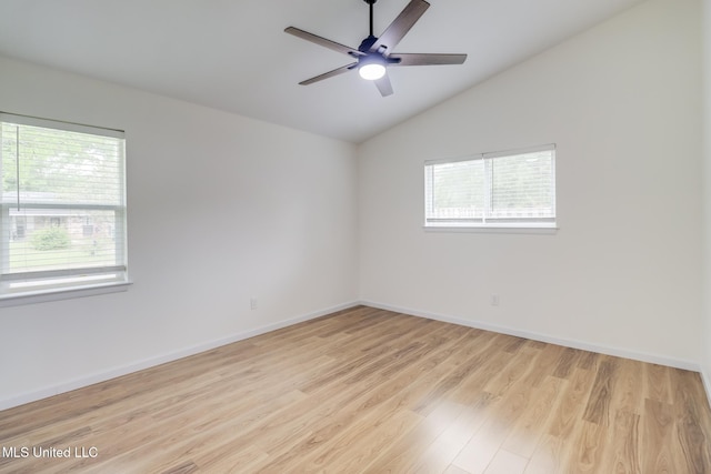empty room with lofted ceiling, a wealth of natural light, a ceiling fan, and wood finished floors