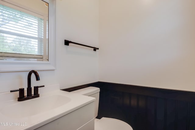 half bath featuring toilet and vanity