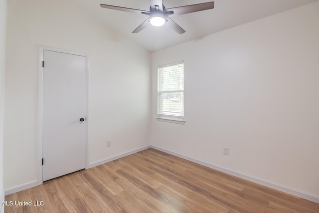 spare room featuring lofted ceiling, ceiling fan, baseboards, and light wood-type flooring