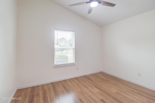 unfurnished room featuring light wood finished floors, lofted ceiling, baseboards, and a ceiling fan