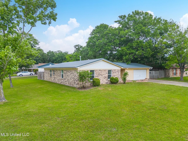 view of side of property with a yard, fence, metal roof, a garage, and concrete driveway
