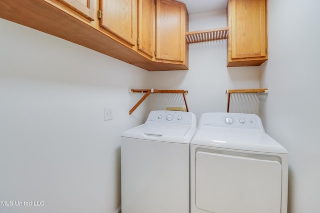 washroom featuring washer and clothes dryer and cabinet space