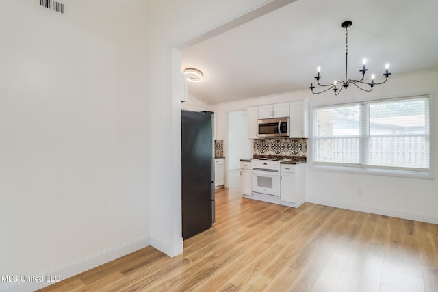 kitchen featuring dark countertops, stainless steel appliances, a notable chandelier, visible vents, and backsplash