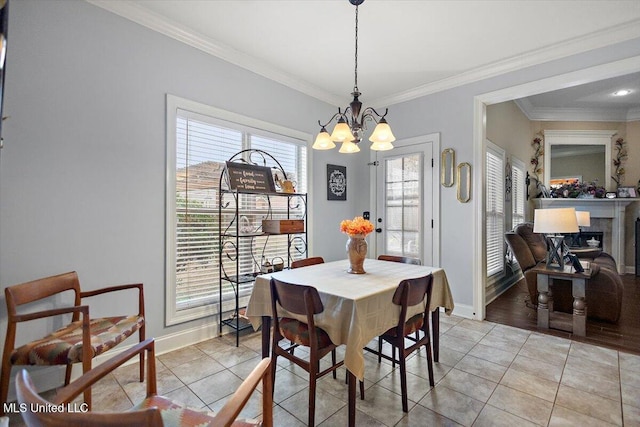 dining room featuring light tile patterned flooring, an inviting chandelier, and crown molding