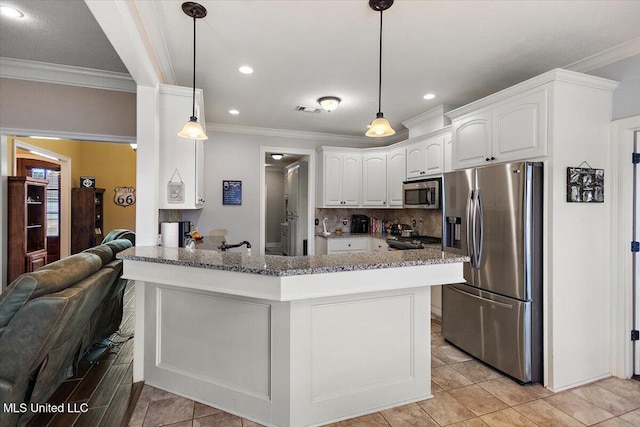 kitchen featuring appliances with stainless steel finishes, white cabinetry, backsplash, hanging light fixtures, and kitchen peninsula