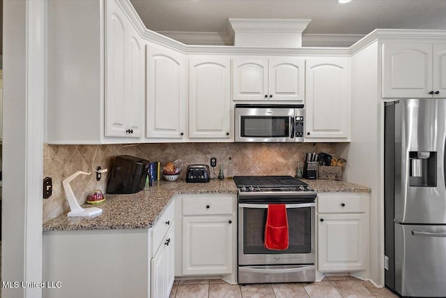 kitchen featuring light tile patterned floors, backsplash, stainless steel appliances, light stone countertops, and white cabinets