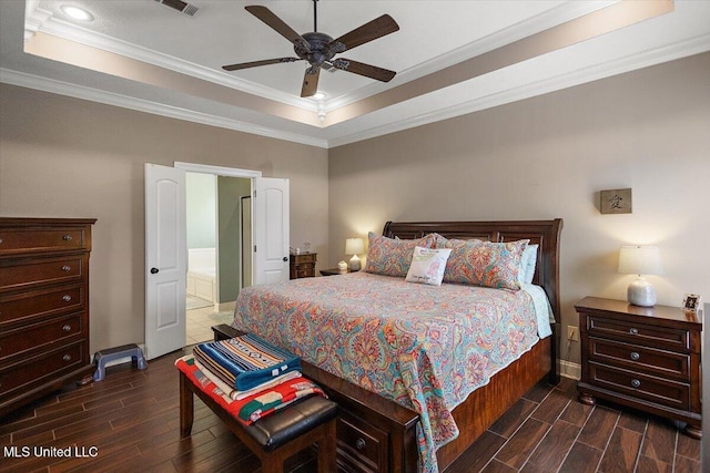 bedroom with a raised ceiling, crown molding, connected bathroom, and ceiling fan