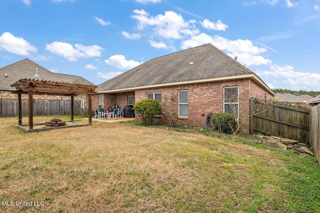 back of house featuring a pergola, a yard, and an outdoor fire pit