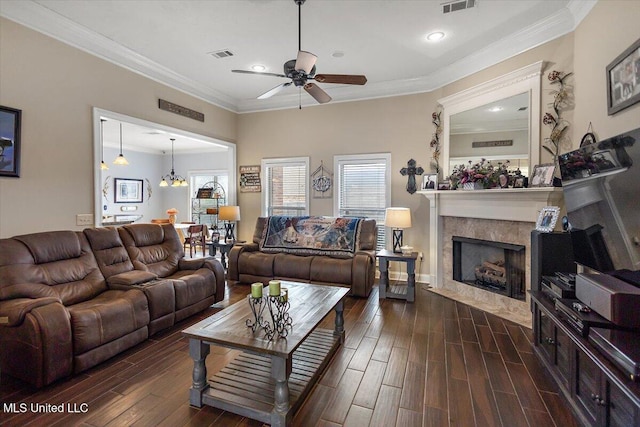 living room featuring crown molding, a premium fireplace, dark hardwood / wood-style floors, and ceiling fan with notable chandelier