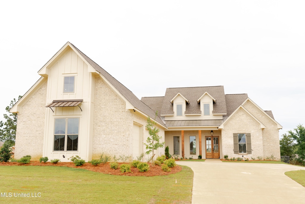 view of front of property with a front yard, a porch, and a garage