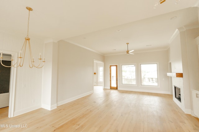 unfurnished living room with ceiling fan with notable chandelier, light hardwood / wood-style floors, and ornamental molding