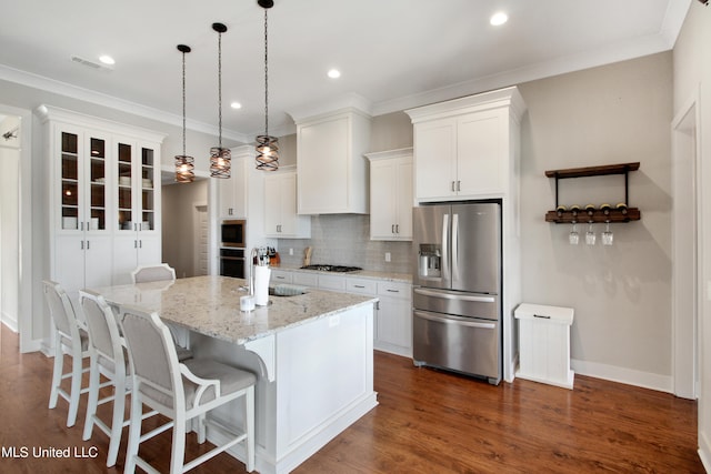 kitchen featuring a kitchen island, hanging light fixtures, white cabinets, appliances with stainless steel finishes, and dark hardwood / wood-style flooring