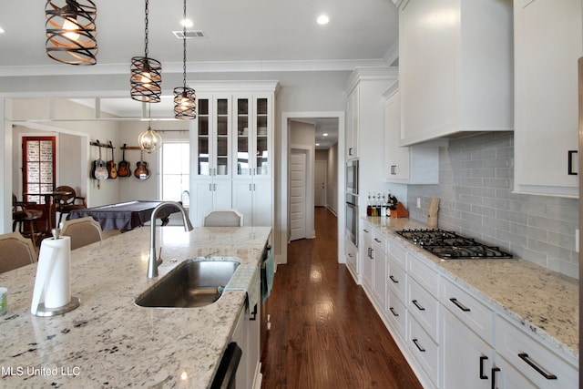 kitchen featuring sink, stainless steel appliances, pendant lighting, white cabinets, and dark wood-type flooring