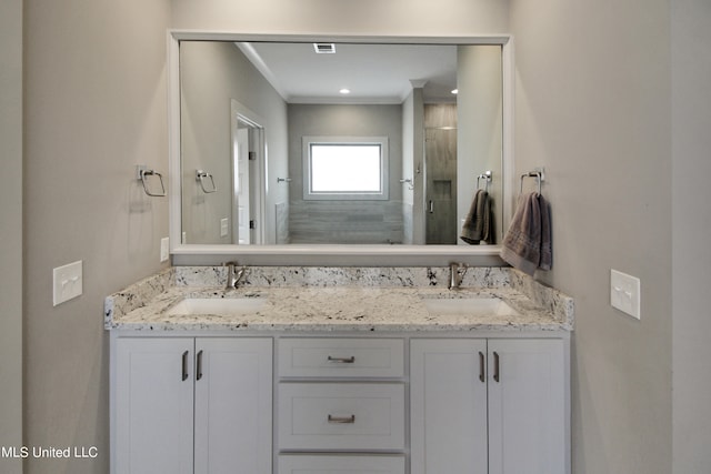 bathroom featuring vanity, crown molding, and a shower with shower door