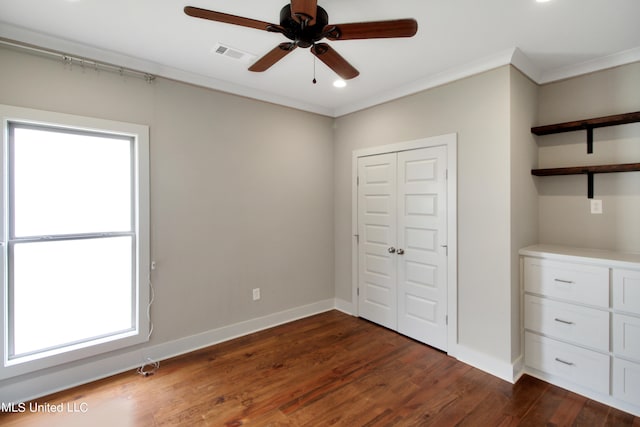 unfurnished bedroom with ceiling fan, multiple windows, and dark hardwood / wood-style floors