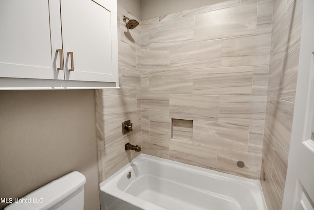 bathroom with toilet and tiled shower / bath