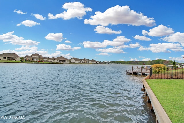 view of dock featuring a lawn and a water view