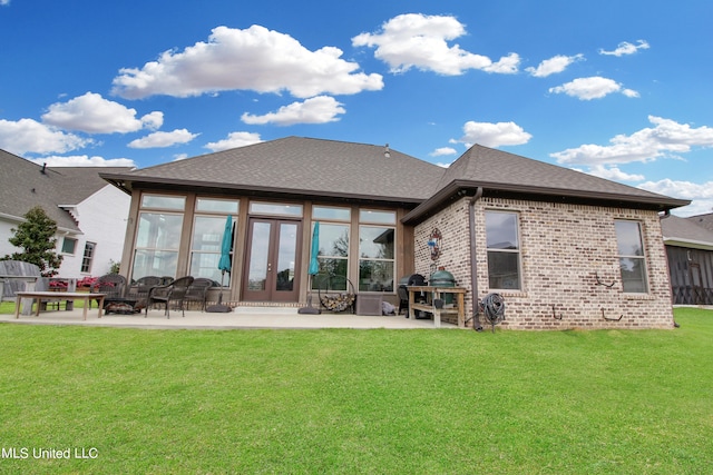 back of property with french doors, a patio area, a lawn, and a sunroom