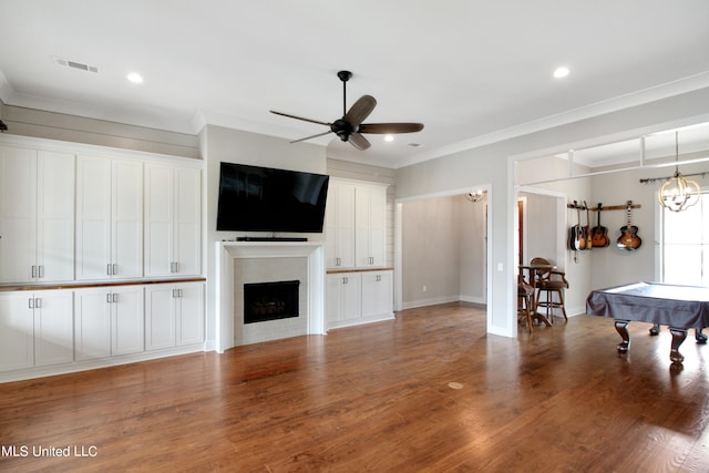 living room with ceiling fan, ornamental molding, wood-type flooring, and pool table