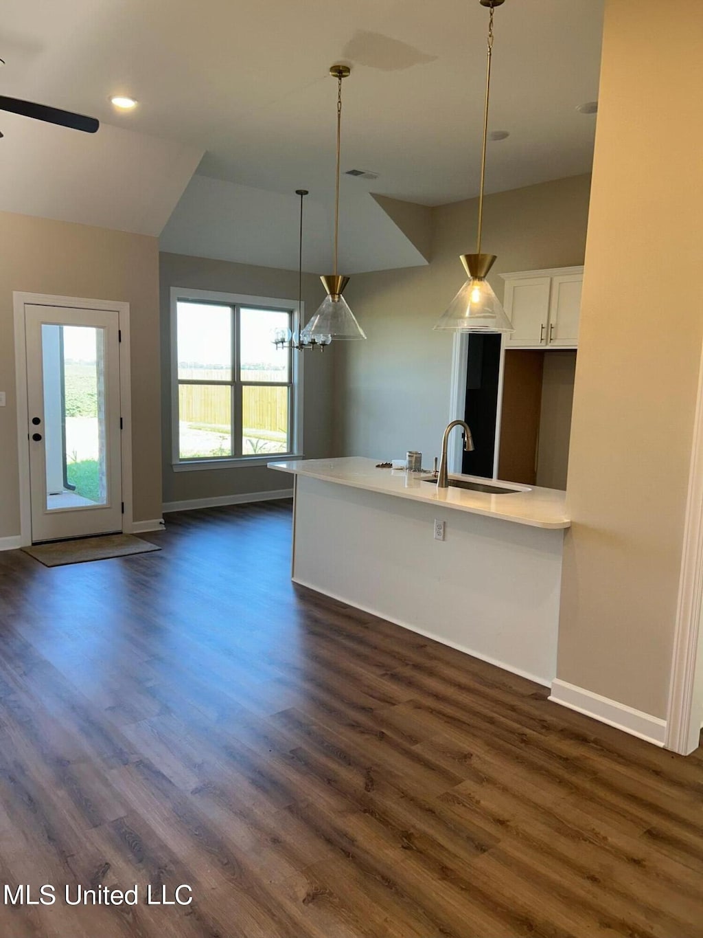 kitchen featuring white cabinetry, sink, hanging light fixtures, and dark hardwood / wood-style flooring