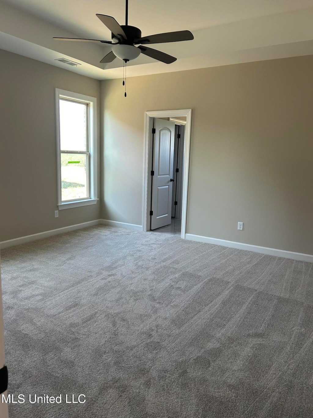 carpeted spare room featuring ceiling fan