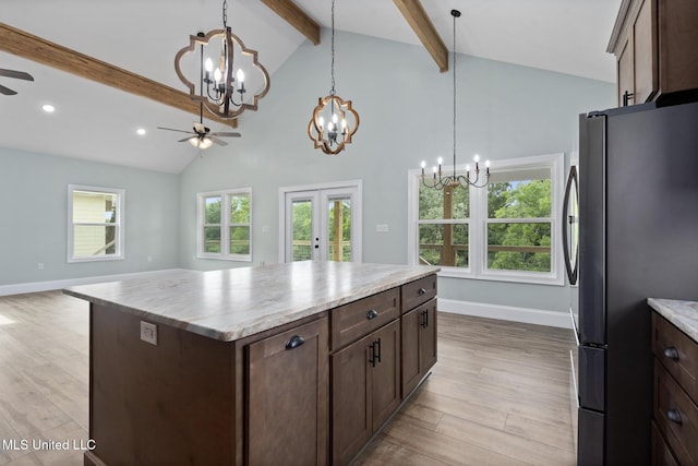 kitchen with beamed ceiling, stainless steel fridge, light hardwood / wood-style floors, a kitchen island, and ceiling fan with notable chandelier