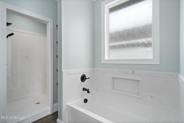 bathroom featuring plus walk in shower and hardwood / wood-style flooring