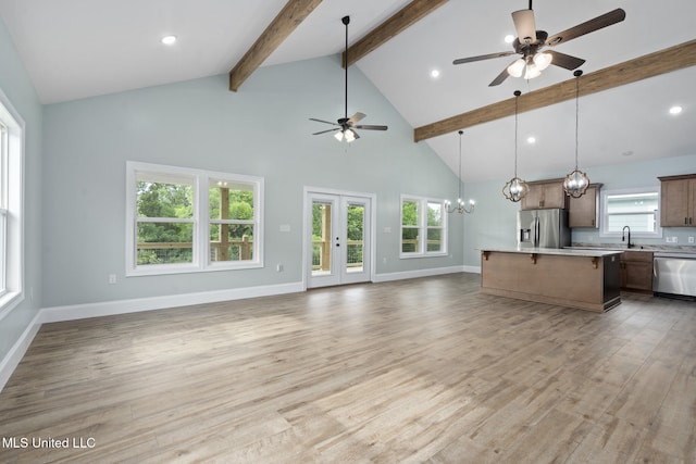 unfurnished living room with beam ceiling, light wood-type flooring, high vaulted ceiling, and sink