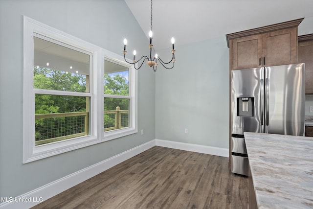 unfurnished dining area featuring dark hardwood / wood-style flooring, lofted ceiling, and a notable chandelier