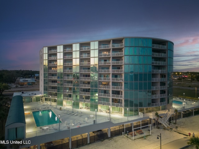 outdoor building at dusk featuring a community pool