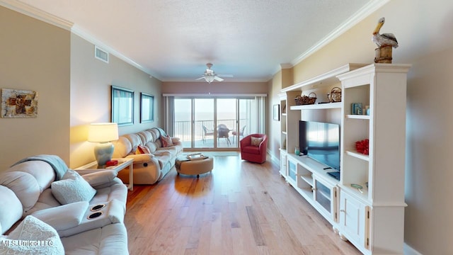 living room with a textured ceiling, light hardwood / wood-style flooring, ornamental molding, and ceiling fan