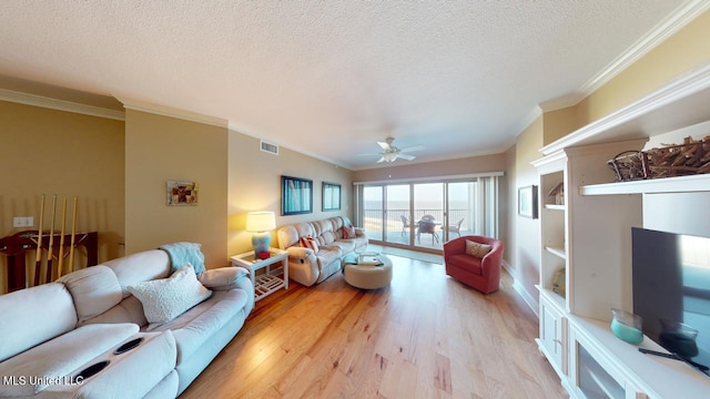 living room with crown molding, ceiling fan, a textured ceiling, and light hardwood / wood-style floors