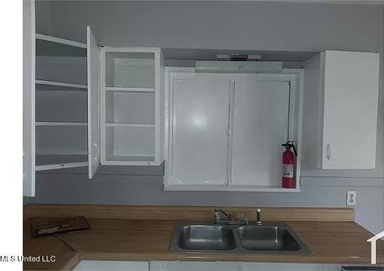 kitchen featuring sink and white cabinets