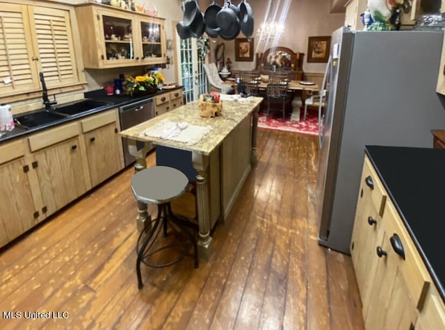 kitchen featuring appliances with stainless steel finishes, light brown cabinetry, sink, light hardwood / wood-style floors, and a center island