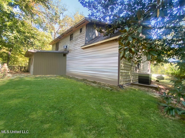 view of side of property featuring a lawn and cooling unit