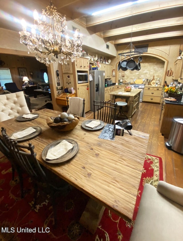 dining space with a notable chandelier, hardwood / wood-style flooring, and beamed ceiling