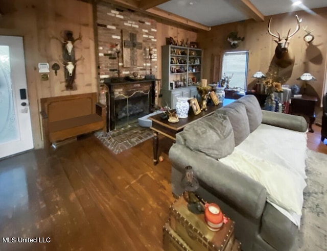 living room with beam ceiling, hardwood / wood-style floors, and a fireplace