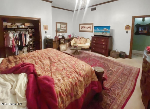 bedroom featuring a closet, crown molding, and carpet