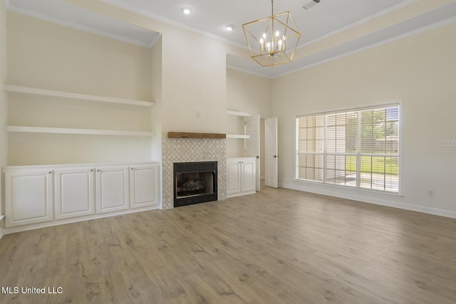 119 Middle Field Dr, Canton, MS 39046 - unfurnished living room with a chandelier, crown molding, light wood-type flooring, a tiled fireplace, and baseboards
