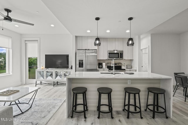 1302 Magnolia St Unit 109, Gulfport, MS 39501 - kitchen featuring a sink, ceiling fan, a kitchen bar, modern cabinets, and appliances with stainless steel finishes