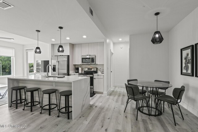 1302 Magnolia St Unit 109, Gulfport, MS 39501 - kitchen with modern cabinets, light wood finished floors, visible vents, and appliances with stainless steel finishes