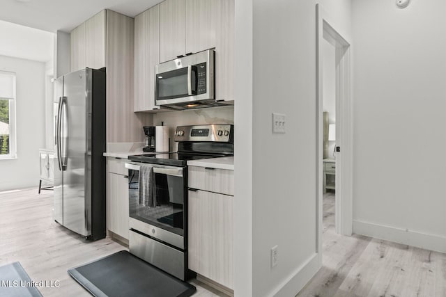 kitchen featuring appliances with stainless steel finishes and light hardwood / wood-style floors