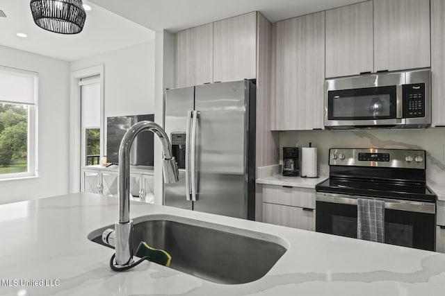 1302 Magnolia St Unit 109, Gulfport, MS 39501 - kitchen featuring stainless steel appliances, modern cabinets, light stone countertops, and a sink