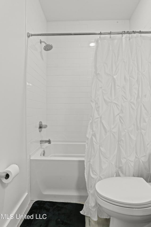 bathroom featuring shower / bath combination with curtain and toilet