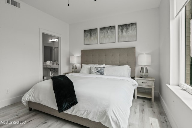 bedroom featuring light hardwood / wood-style floors and ensuite bath