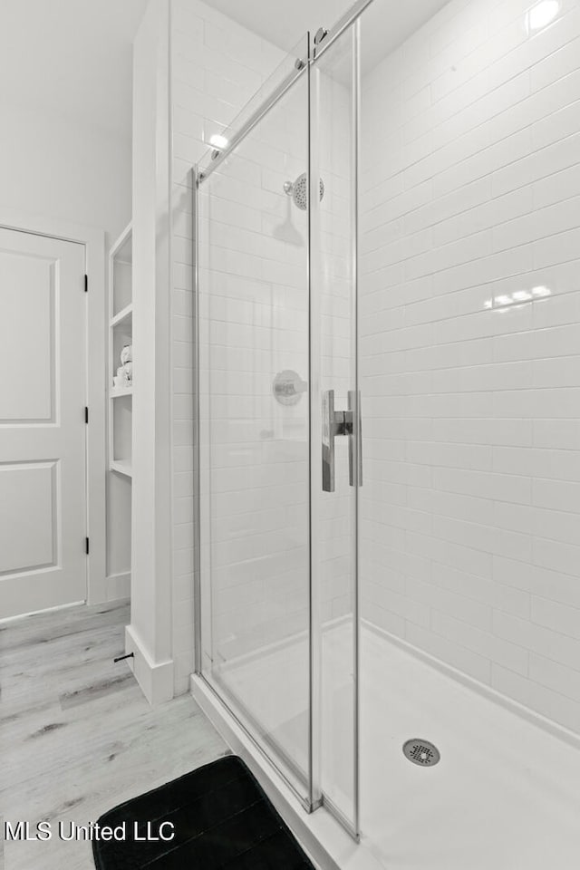 bathroom featuring a shower with door and hardwood / wood-style flooring